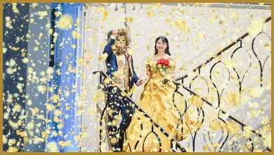 黄色のドレスを着た新婦と仮面をつけた新郎が手をつなぎながら登場する結婚式の一場面