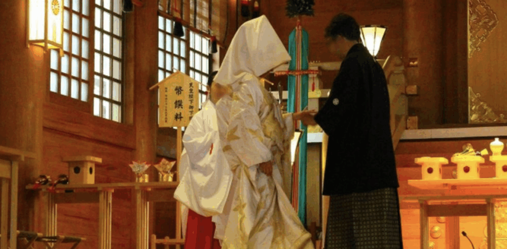 神前式で指輪の交換を行う新郎新婦の姿