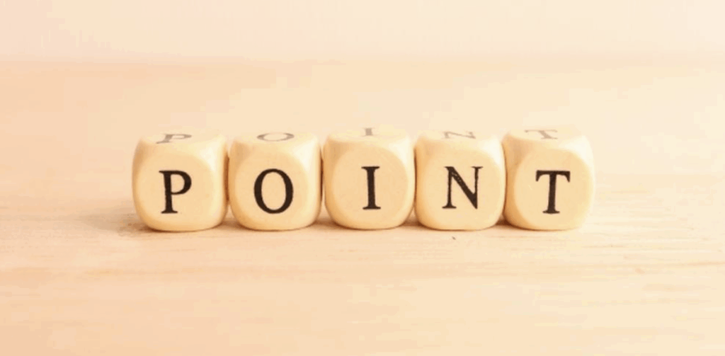 木目調の背景に並べられた「POINT」のサイコロ型ブロック