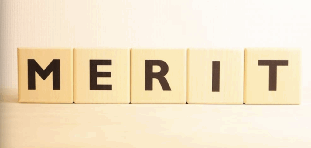 木のテーブル上に並べられた「MERIT」の文字ブロック